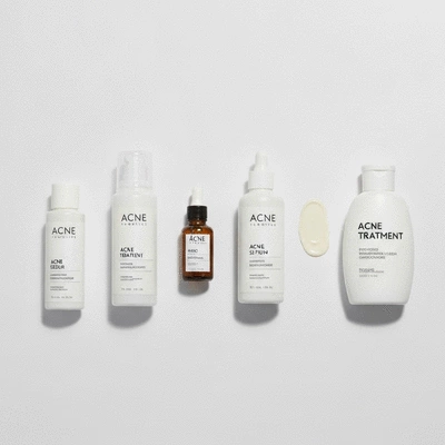 Flat lay of various skincare products for acne treatment on a neutral background