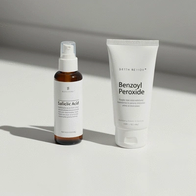 Close-up of skincare products with salicylic acid and benzoyl peroxide on a clean white background
